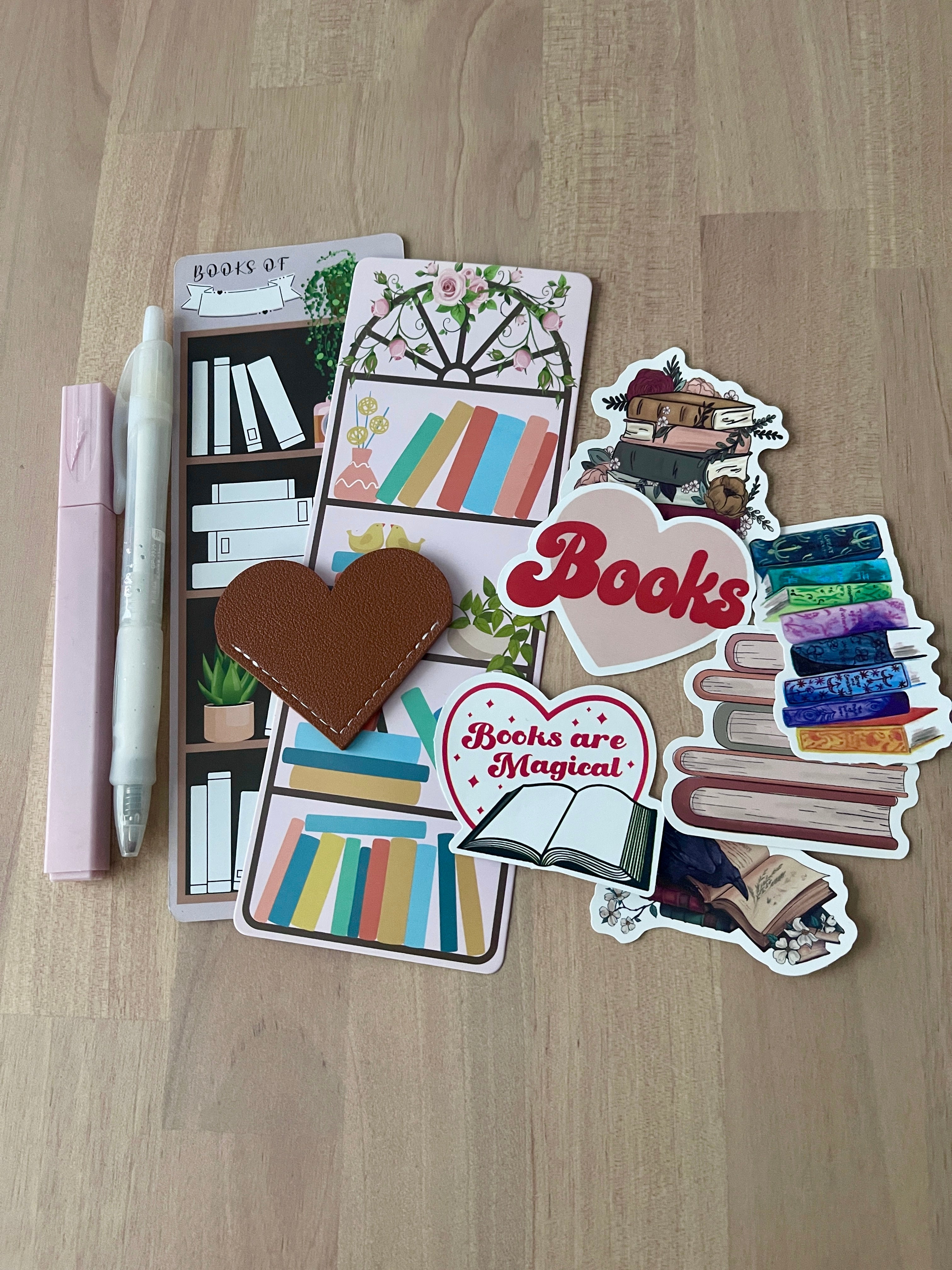 Collection of book-themed stickers and a pen on a wooden surface