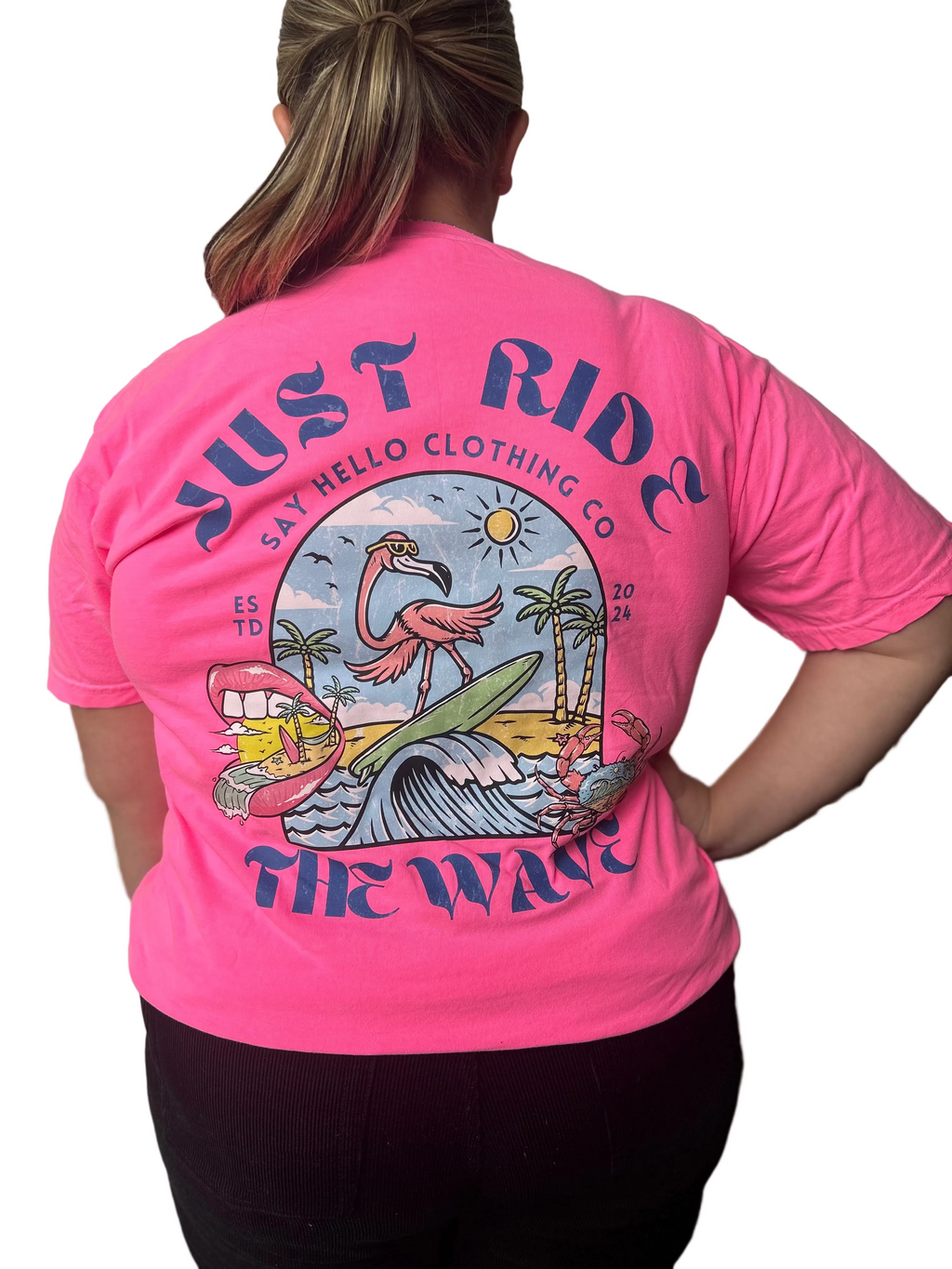 Person wearing a pink t-shirt with a flamingo graphic and text on the back.