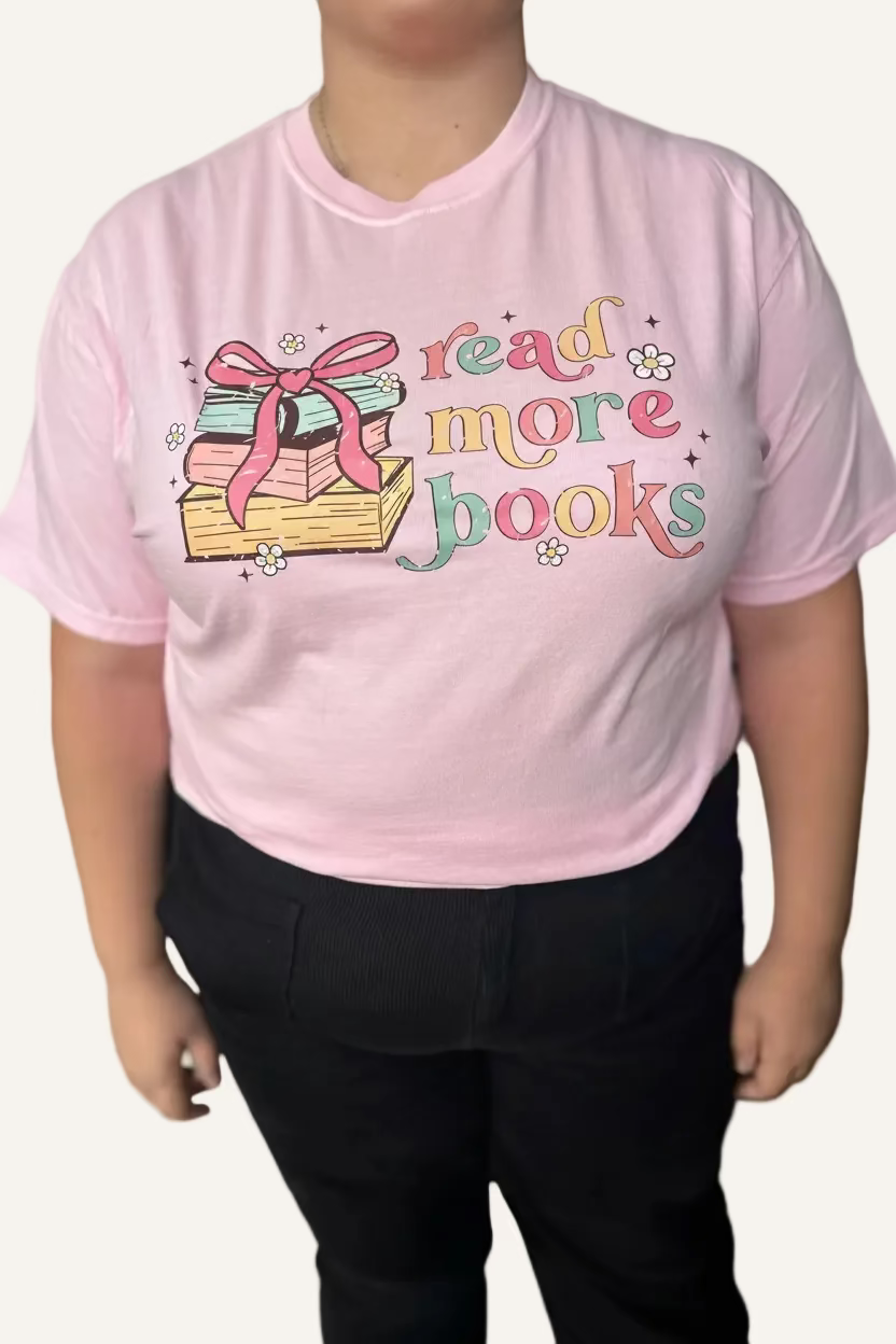 Person wearing a pink t-shirt with 'read more books' text and book illustration.